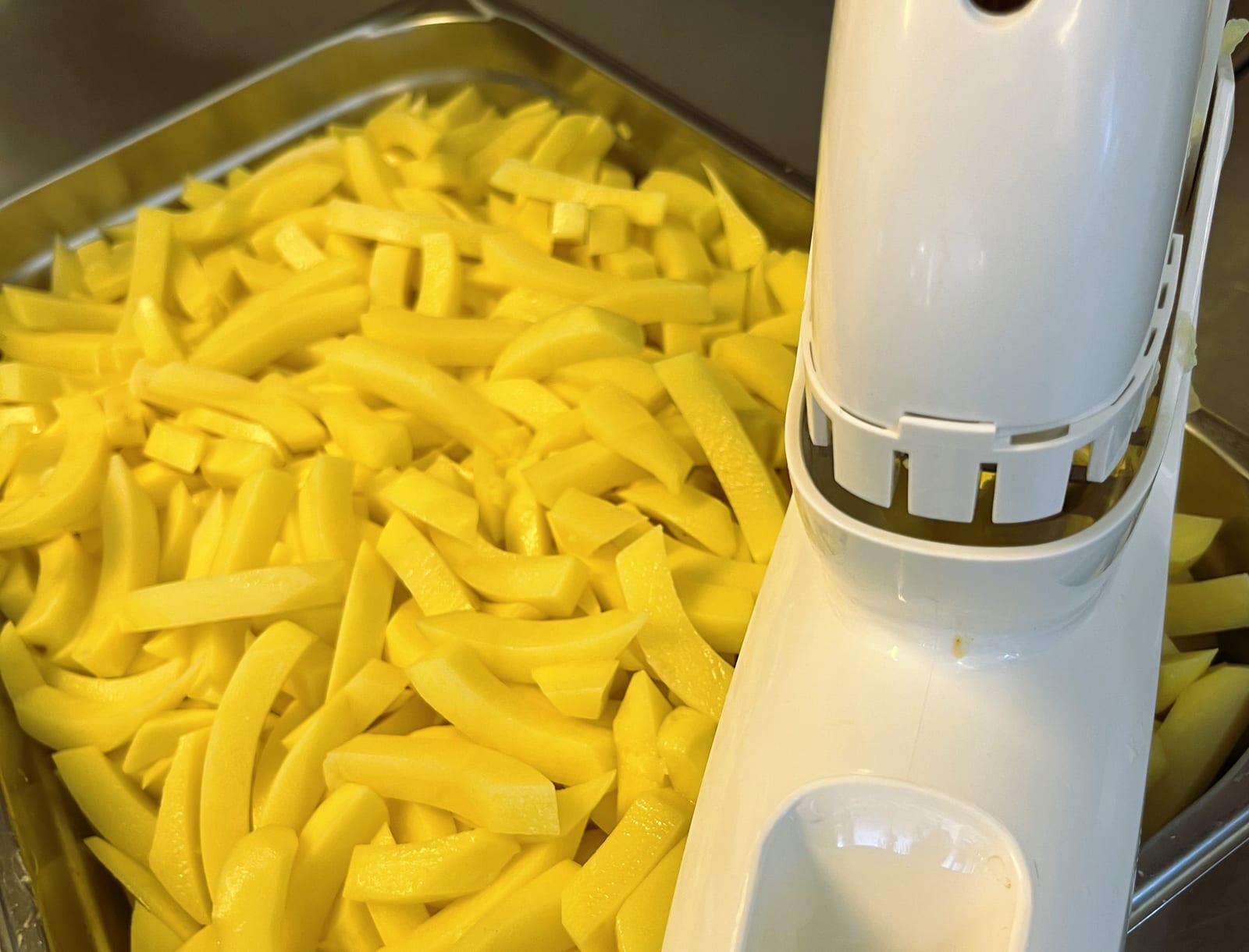 Frisch geschnittene Kartoffelstäbchen in einer Wanne in der Jausenmacher-Küche