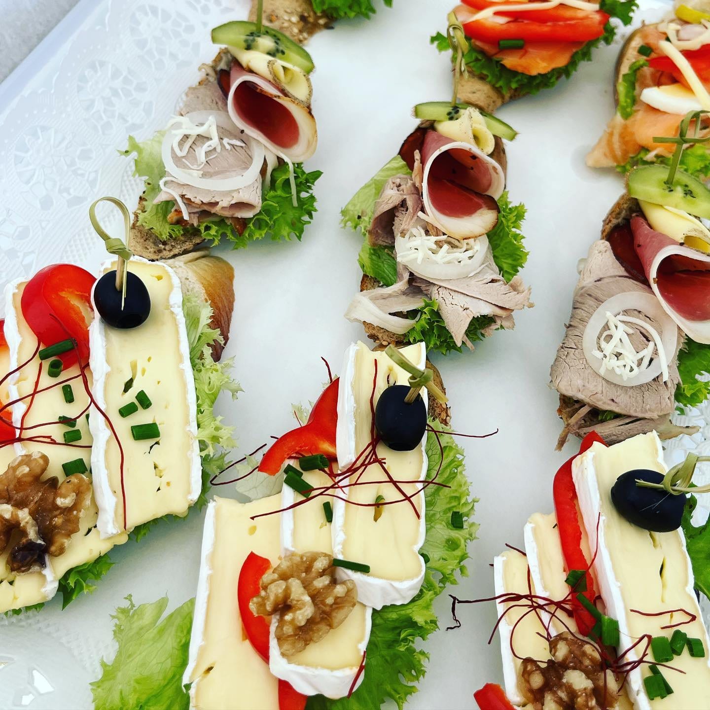 © Die Jausenmacher GmbH Garnierte Brötchen mit Brie, Walnüssen, Trauben und Oliven